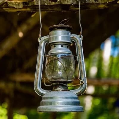 A kerosene lantern hanging from a wooden beam