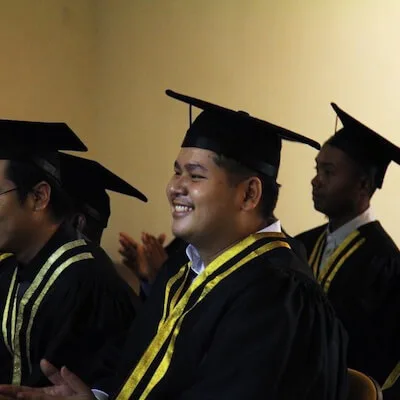 Graduates in caps and gowns applauding at a Solar Academy graduation